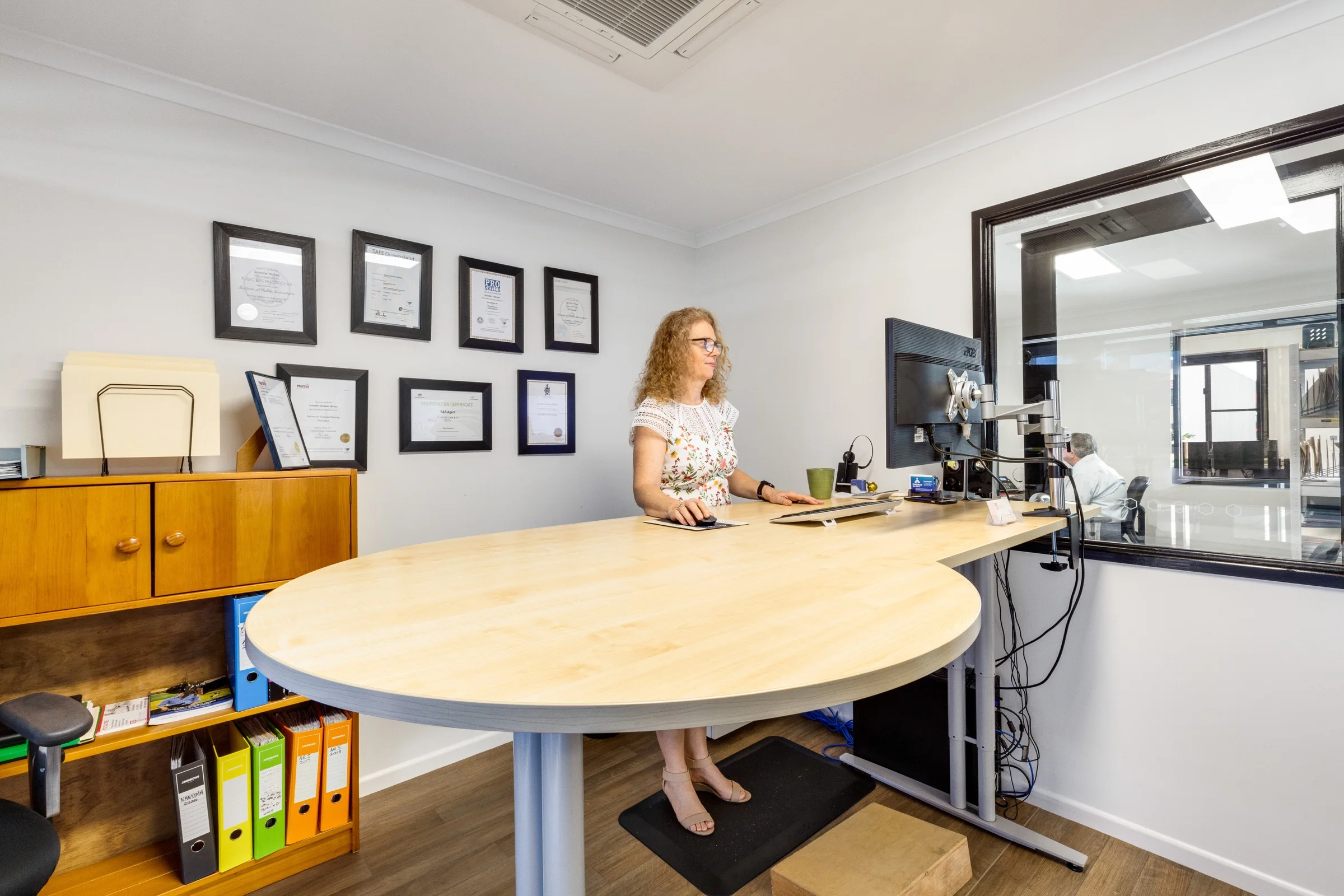 Jen working in the Ready Accounting office, with professional qualifications displayed behind her